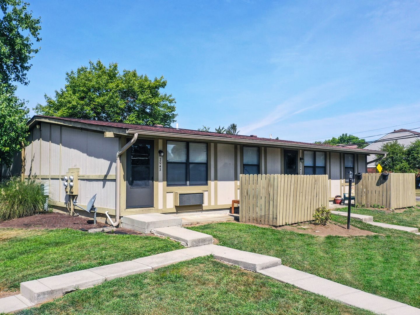 Completed apartment exterior with restored siding, new entries and finished landscaping.