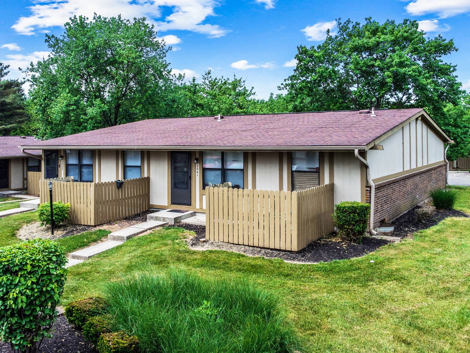 Apartment community exterior with new roofing, siding and landscaping after renovation.